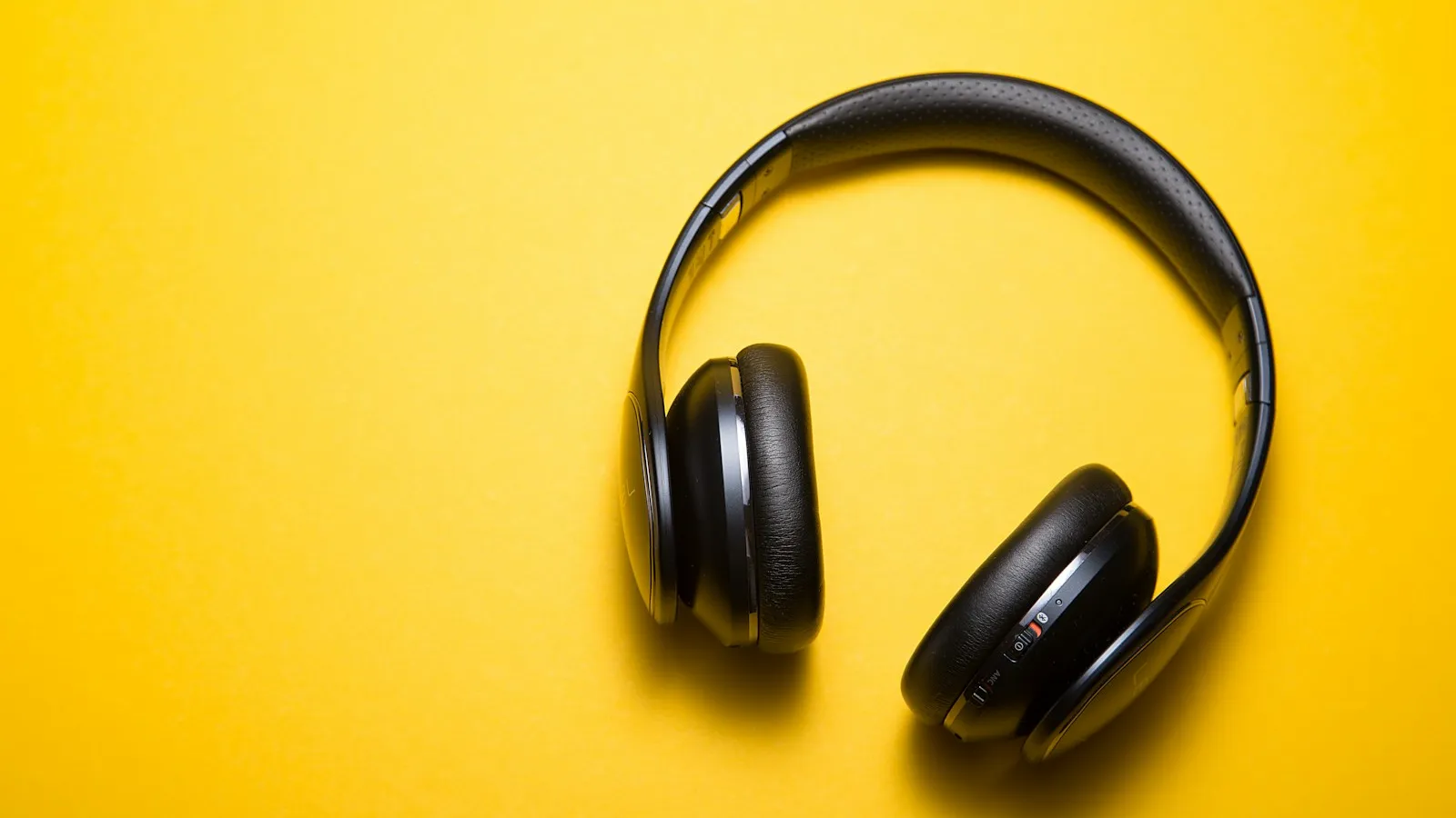 Over-ear headphones resting on a wooden desk