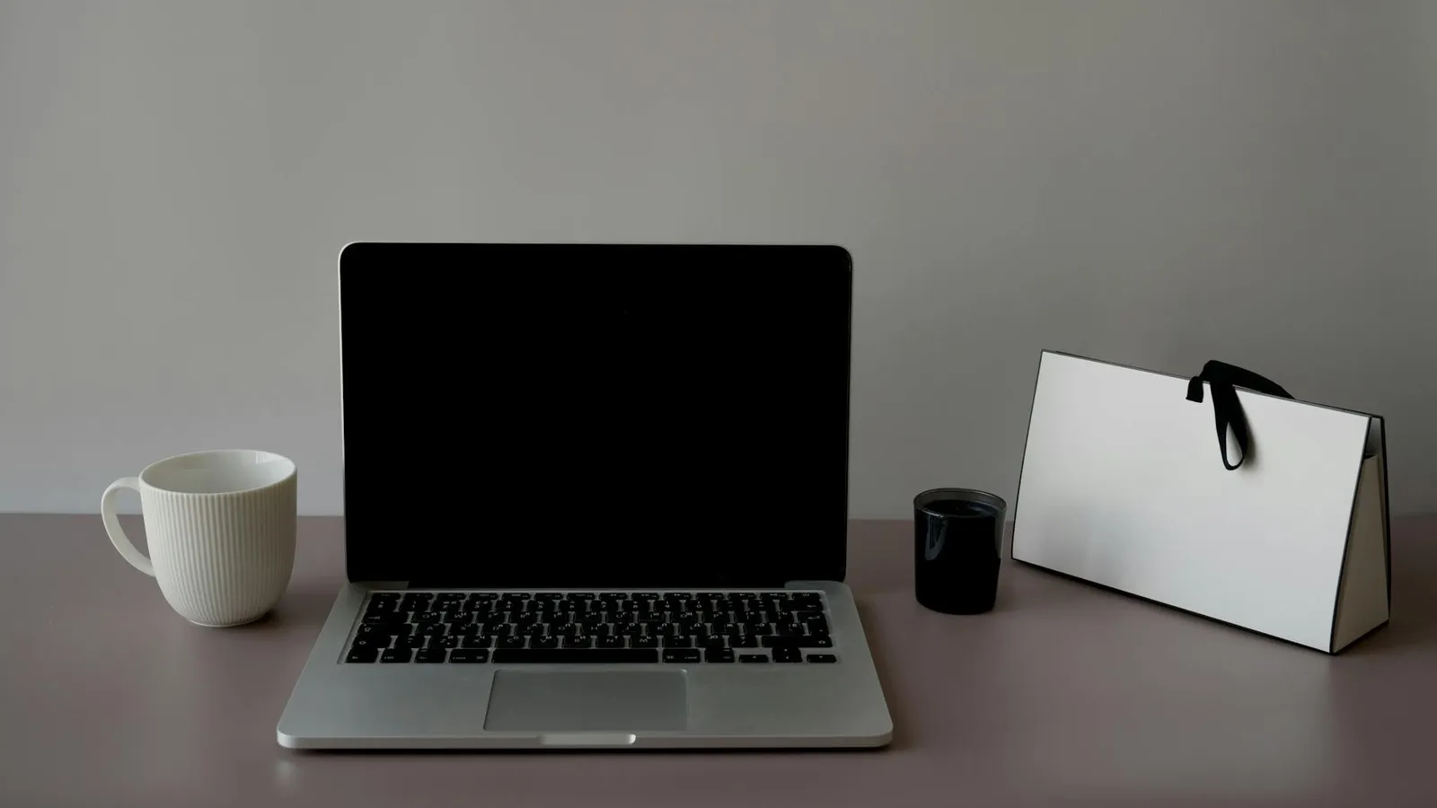 A minimal workspace with a laptop and a clean bag on a desk